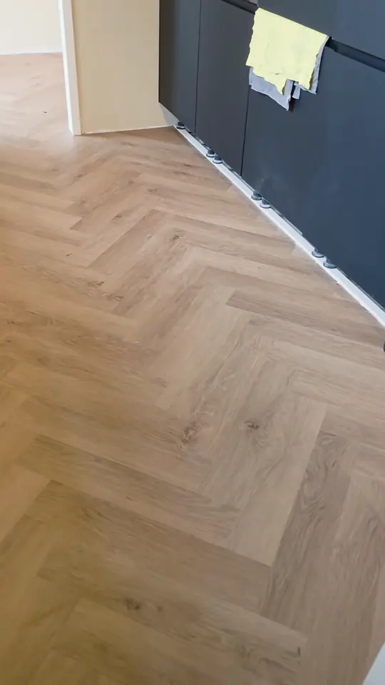 Naturel visgraatvloer langs een kast